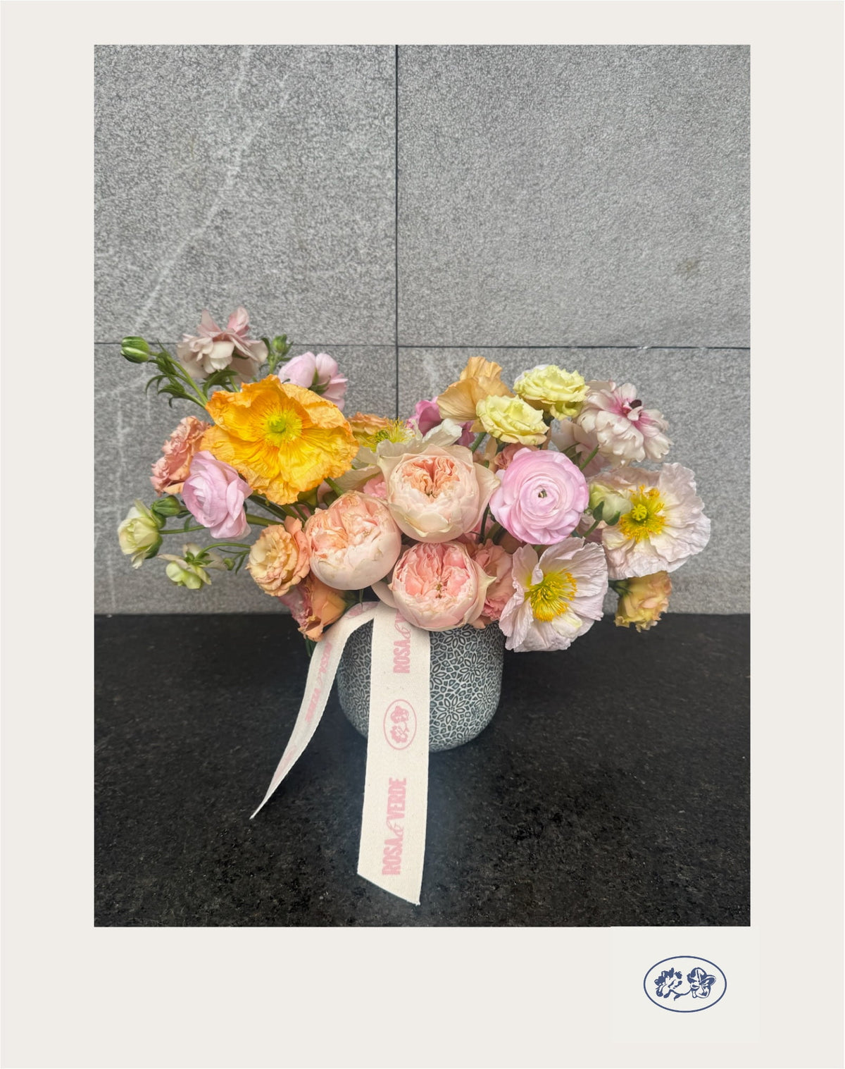 Arreglo floral Alejandra en tonos naranjas y rosas con lisianthus, amapolas, ranúnculos y rosas inglesas